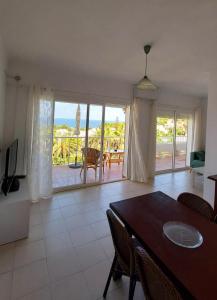 ein Esszimmer mit einem Tisch und Meerblick in der Unterkunft Siesta Mar Apartamentos Ibiza in Santa Eulària des Riu