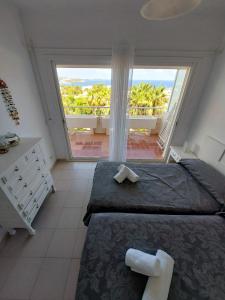 a bedroom with a large bed and a large window at Siesta Mar Apartamentos Ibiza in Santa Eularia des Riu