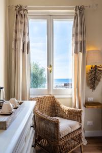 une chaise en osier assise devant une fenêtre dans l'établissement Gian Paul Hotel, à Cavi di Lavagna