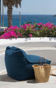 a blue couch and a basket on a table with flowers at KAMEO, Antiparos in Antiparos
