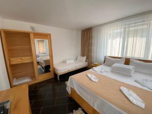 a hotel room with two beds and a mirror at Casa RBK in Vama Veche