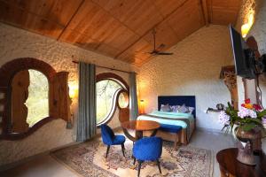 a bedroom with a bed and a table and chairs at Chirping Hills Resort,Bhimtal in Bhīm Tāl