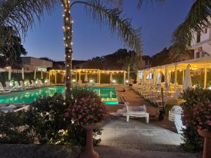 ein Schwimmbad mit Liegestühlen und ein Resort bei Nacht in der Unterkunft Sole D'oriente in Palmi