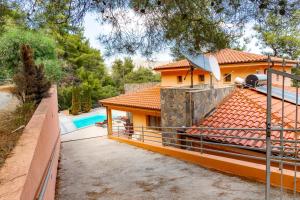 a house with a swimming pool and a fence at Villa Hillcrest Panorama by Ezoria Villas in Moniatis