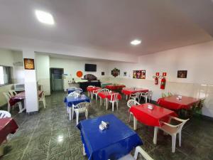 a restaurant with red and blue tables and chairs at Hotel Jin Ju in Arujá