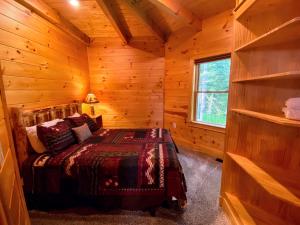 1 dormitorio con 1 cama en una cabaña de madera en OR Luxury yurt-like home in Bretton Woods with private beach firepit AC fishing and trails, en Carroll