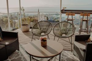 Mossel Bay的住宿－水上碼頭賓館，美景阳台配有两把椅子和一张桌子