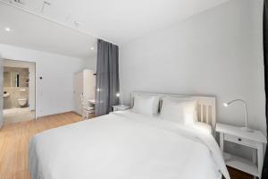 biała sypialnia z dużym łóżkiem i łazienką w obiekcie VibeStudio 302 - Central - AC - Near Parking w Wiedniu