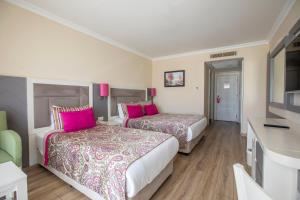 two beds in a hotel room with pink pillows at Orange County Belek in Belek