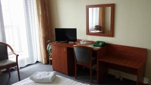 a room with a desk with a television and a mirror at Hotel Krystal in Prague