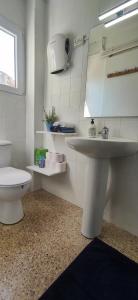 a bathroom with a white sink and a toilet at Casa Petits in Manresa