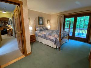 1 dormitorio con cama y ventana grande en O9 NEW Renovated Bretton Woods slopeside condo with 2 living rooms foosball air hockey en Carroll