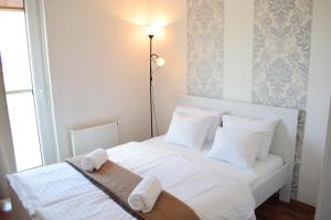 Un dormitorio con una cama blanca con toallas. en Corvin Center Suites, en Budapest