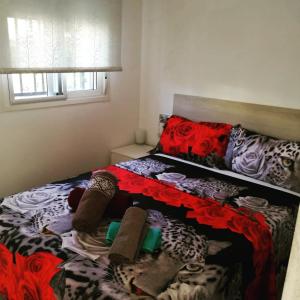 um pequeno quarto com uma cama vermelha e preta em Escapada de ciudad en aire libre em Calafell