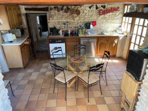 een keuken met een glazen tafel en stoelen. bij La Source in Breuil