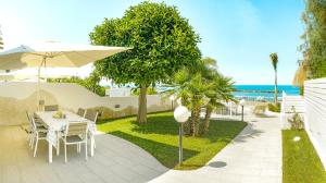 eine Terrasse mit einem Tisch und einem Sonnenschirm in der Unterkunft Villa di Lusso sul Mare a Diamante - Villa Ventre in Belvedere Marittimo