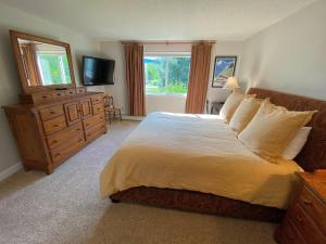 - une chambre avec un lit, une commode et une télévision dans l'établissement F5 Renovated home on golf course in Bretton Woods AC, à Carroll