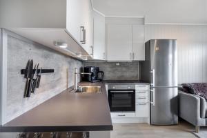 a kitchen with white cabinets and a stainless steel refrigerator at Third floor appartement (5min from train station) in Eidsvoll