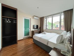 a bedroom with a large bed and a large window at Mii Smile Hotel Penang in George Town