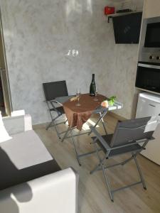 uma cozinha com uma mesa com duas cadeiras e um estofador de mesa em Escapada de ciudad en aire libre em Calafell