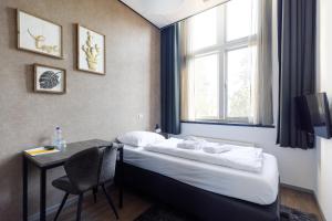 a room with a bed, chair and a window at B&B Landgoed De Grote Beek in Eindhoven