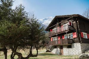 a building with a balcony and a mountain in the background at Chalet La Balma in Macugnaga