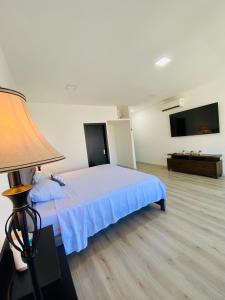 1 dormitorio con 1 cama y TV de pantalla plana en Habitación Ejecutiva cómoda y acogedora - Centro de Manta, en Manta