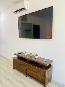 un espejo en una pared con dos plantas en una mesa de madera en Habitación Ejecutiva cómoda y acogedora - Centro de Manta, en Manta