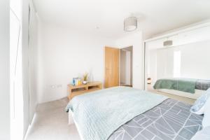 a white bedroom with a bed and a window at LiveStay-Modern One Bed Apartment in Private Building in Luton