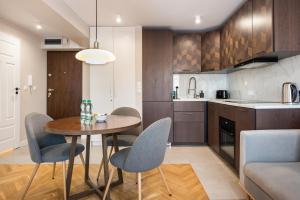 a kitchen and dining room with a table and chairs at Powiśle Chic Apartment in Warsaw
