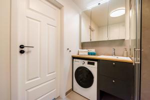 biała pralka i suszarka w łazience w obiekcie Powiśle Chic Apartment w Warszawie +13 zdjęć
