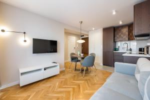 a living room with a couch and a table with chairs at Powiśle Chic Apartment in Warsaw