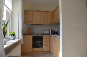 a small kitchen with wooden cabinets and a microwave at Buttgereit in Kosel