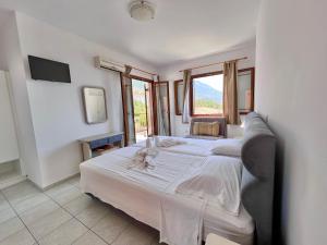 ein Hotelzimmer mit 2 Betten und einem TV in der Unterkunft Aristomenis Studios in Vlachata