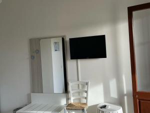 a room with a chair and a television on a wall at Agriturismo Tenuta Pozzello in Torre dell'Orso
