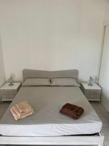 a white bed with two nightstands and two towels on it at Agriturismo Tenuta Pozzello in Torre dell'Orso