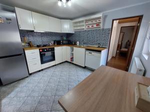 cocina con armarios blancos y mesa de madera en Cozy, quiet & family friendly in Arad en Arad