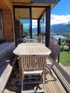 una mesa de madera y sillas en la cubierta de una casa en Chalet Spa Fora Pista, en Bolquere Pyrenees 2000