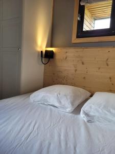 1 dormitorio con 2 almohadas blancas en Chalet Spa Fora Pista, en Bolquere Pyrenees 2000