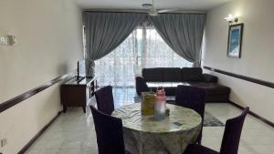a living room with a table and a couch at Condo D 'Savoy 3 Room in Kampong Alor Gajah