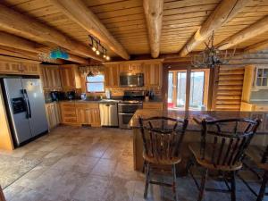 a kitchen with a refrigerator and a table with chairs at SI INCREDIBLE VIEWS from this log cabin with large deck huge yard fire pit hot tub in Dalton