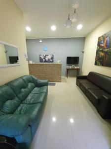 a living room with a couch and a television at Hotel Jin Ju in Arujá