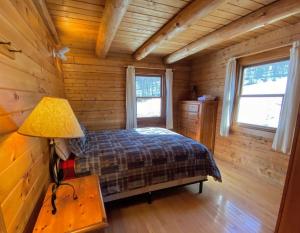 1 dormitorio en una cabaña de madera con 1 cama y 1 lámpara en SI INCREDIBLE VIEWS from this log cabin with large deck huge yard fire pit hot tub en Dalton