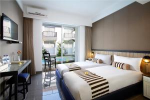 Una habitación de hotel con una cama grande y un escritorio. en 7 Bidadari Hotel Seminyak, en Seminyak