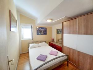 1 dormitorio con 1 cama con 2 almohadas moradas en Apartment Bella Vista en Korčula