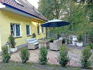 a patio with a table and chairs and an umbrella at Am Deich 43 in Zingst