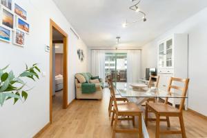 comedor y sala de estar con mesa de cristal y sillas en ApartUP Patacona Beach I, en Valencia