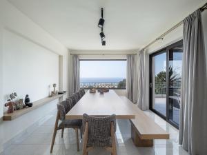 a dining room with a table and a large window at Villa Heora - The Floating Residence in Tria Monastiria