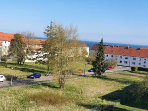 a building with cars parked in a parking lot at FEWODAYs Ferienwohnung in Sassnitz - Ruegen in Sassnitz