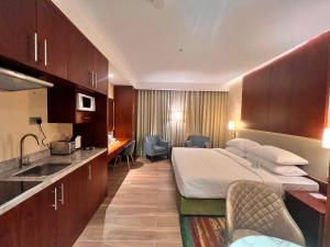 City Seasons Suites في دبي: غرفة الفندق بسرير ومغسلة
